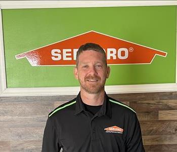 photo of male employee standing in front of servpro sign